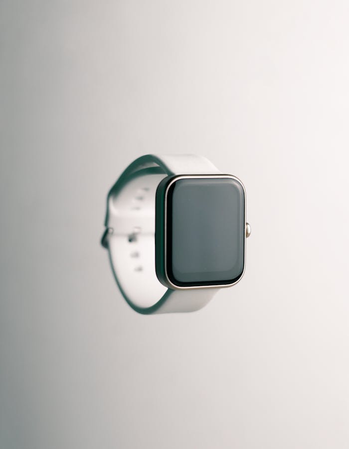 Close-up of a modern smartwatch with a white strap, showcasing sleek design and technology.