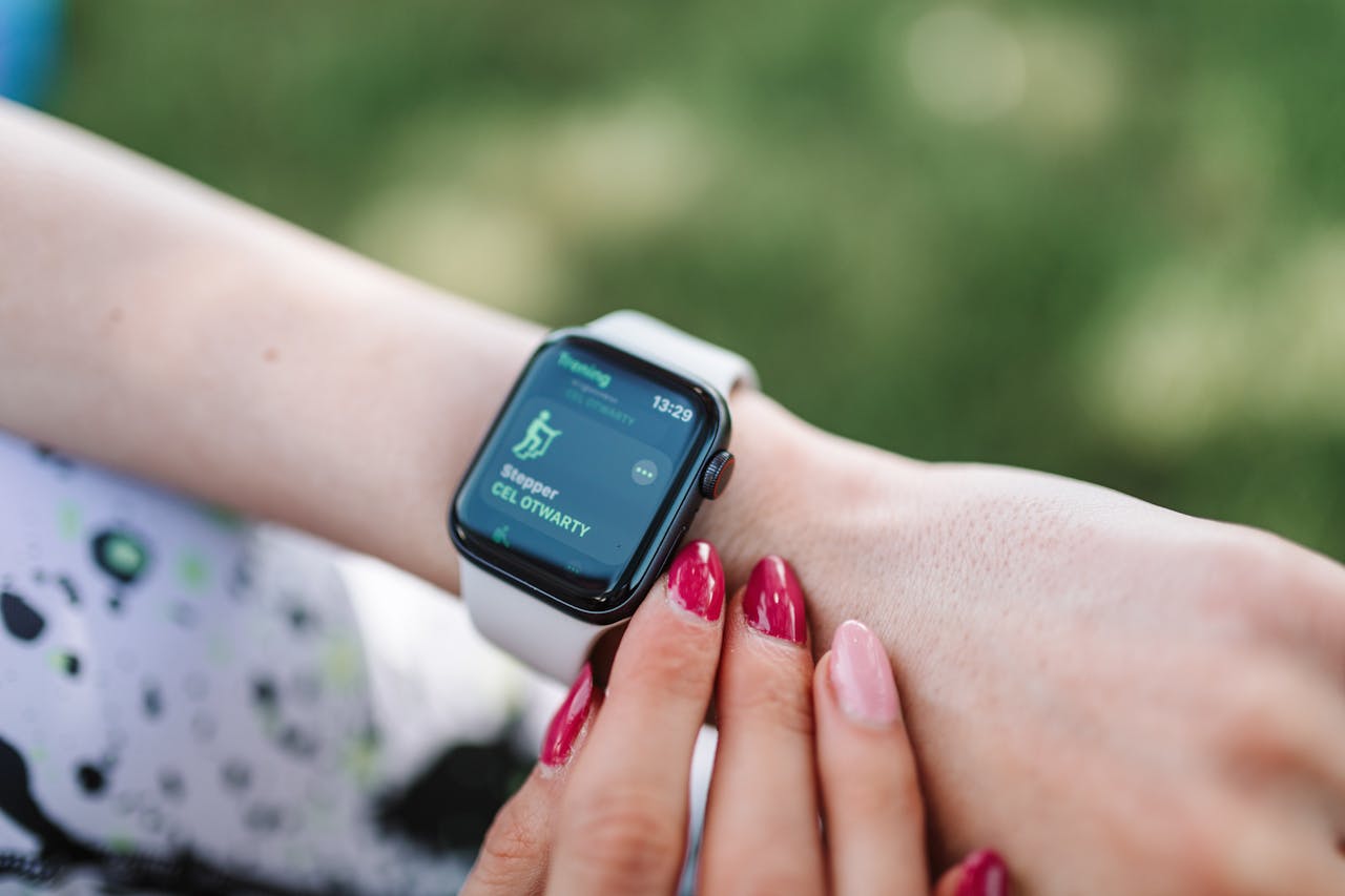 Woman interacting with a smartwatch outdoors displaying a fitness tracking app.